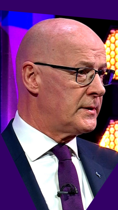 A head and shoulders shot of First Minister John Swinney in a studio setting.