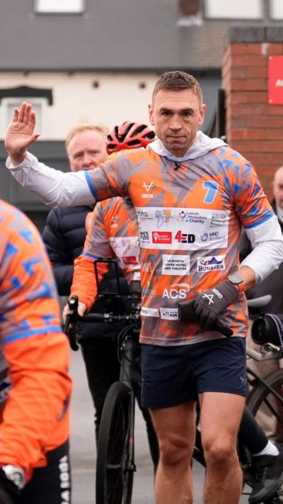 Kevin Sinfield waves while running in Sheffield