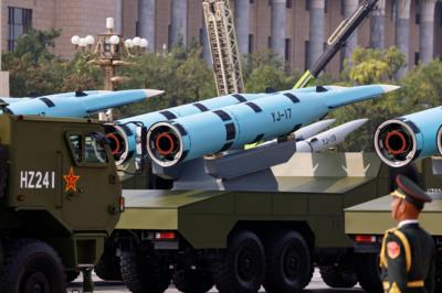 A member of the People's Liberation Army stands as YJ-17 hypersonic anti-ship missiles are displayed during a military parade - the modern rockets have YJ-I7 written on their sides sit on the back of green transport vehicles