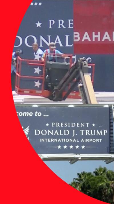 Workers installing a 'Welcome to President Donald J. Trump International Airport' sign