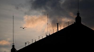Silhouette of the chimney on the Sistine Chapel as the sun sets