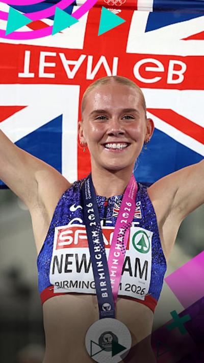 Emily Newnham holds the Union Flag behind her head while smiling after earning silver in the 400m hurdles