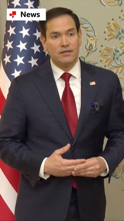 Marco Rubio wearing a blue suit and red tie