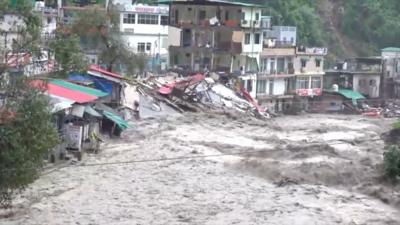 Gushing water sweeping away everything in its way and damaging homes and shops in a hilly city in India's Uttarakhand