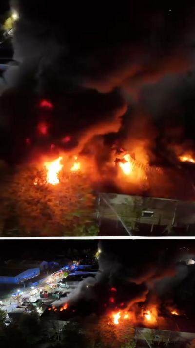 Aerial view of fire at Thetford recycling centre with flame and thick black smoke rising into the night sky.