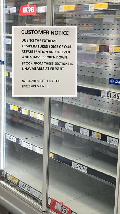 A supermarket fridge cabinet is empty. The shelves display the names of the items and prices which should be on them. A sign reads: 'Customer Notice. Due to the extreme temperatures some of our refrigeration and freezer units have broken down. Stock from these sections is unavailable at present. We apologise for the inconvenience.'