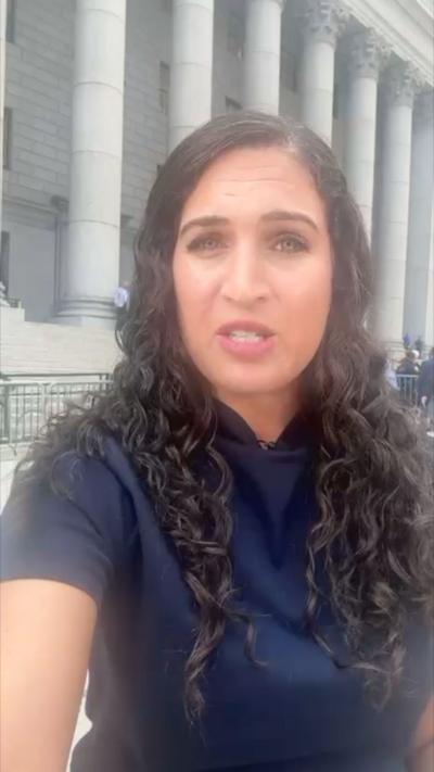 Nada wearing blue outside the courtroom.