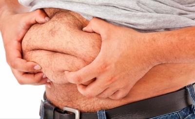 Close-up of a man holding his belly fat