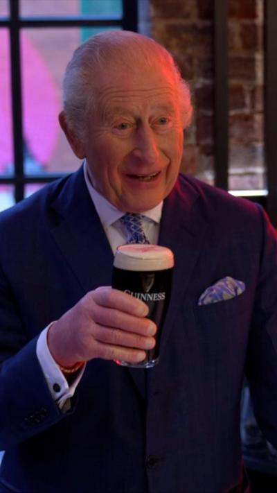 The King holding a pint of Guinness.