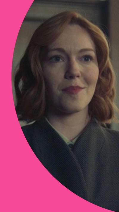 A woman with red hair smiles in a courtroom