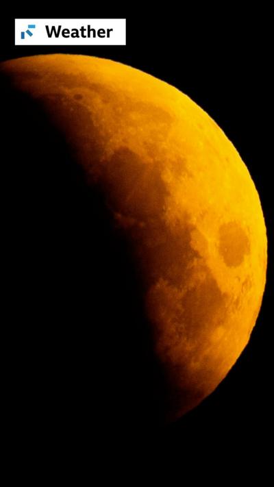 A lunar eclipse is visible above Surrey Quays in London 