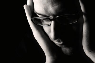 Black and white image of man with head in his hands