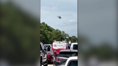 A helicopter hovers over a traffic jam