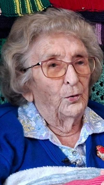 Anneira Davies yn eistedd mewn cadair