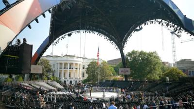 A large structure painted red and blue is in front of the White House on the South Lawn.