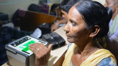 An Indian woman getting her fingerprints read during the registration process for Aadhaar cards