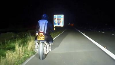 Picture in the dark of motorcyclist in the hardshoulder