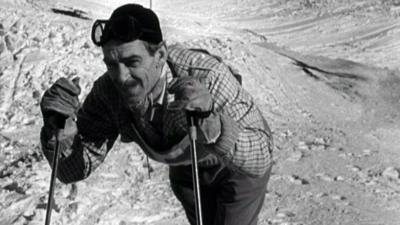 Bill Bracken prepares to take off from the top of a ski slope.