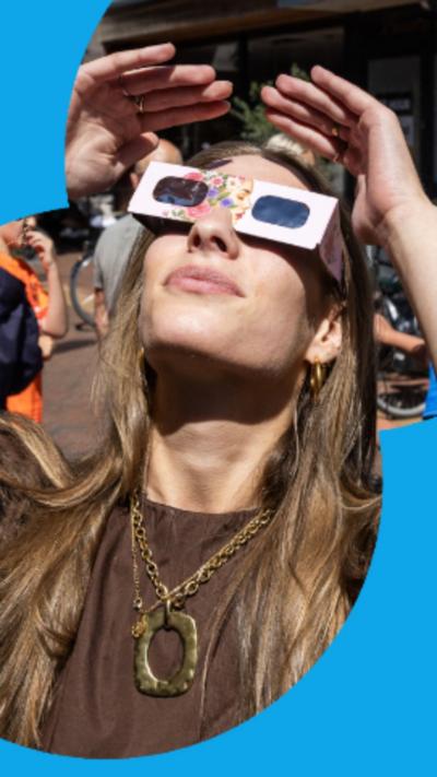 Woman with long blonde hair wearing solar eclipse glasses
