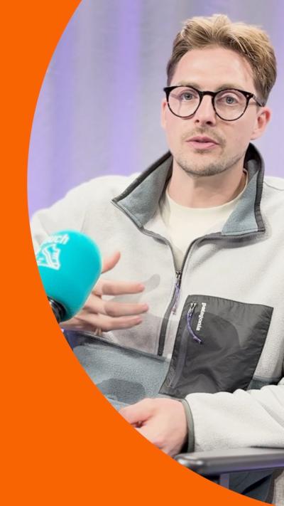 Dr Alex speaking into a blue microphone