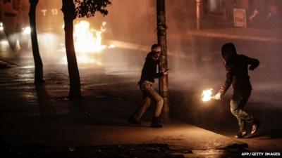 Protesters throw molotov cocktails towards a water cannon during clashes with police on October 10, 2015 at the gazi district in Istanbul