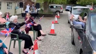 Families wave at care home residents