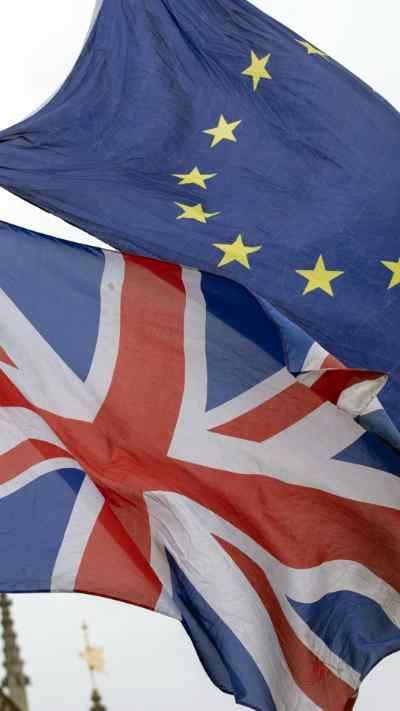 A Union flag and European Union flag flutter together in the wind.