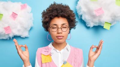 Image of person meditating surrounded by clouds covered in sticky notes