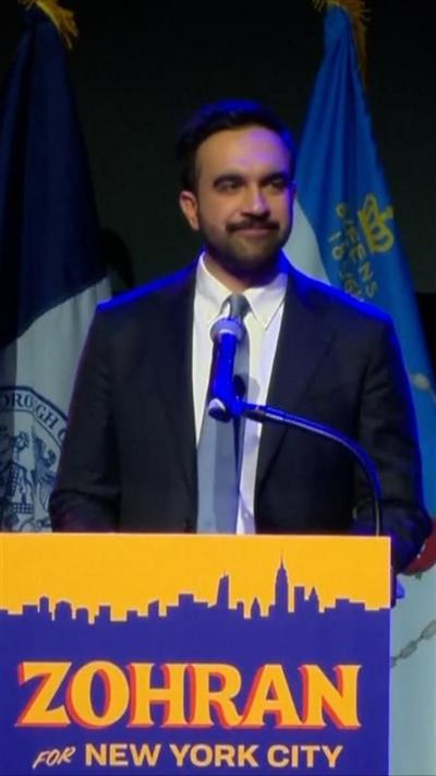 Zohran Mamdani speaking at podium