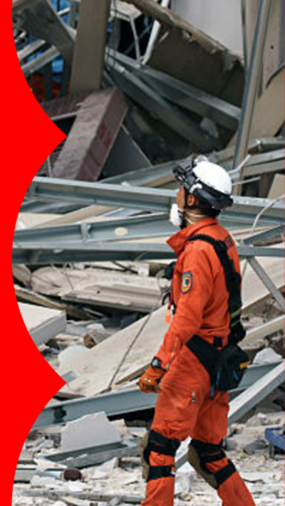 A rescue worker next to a collapsed building