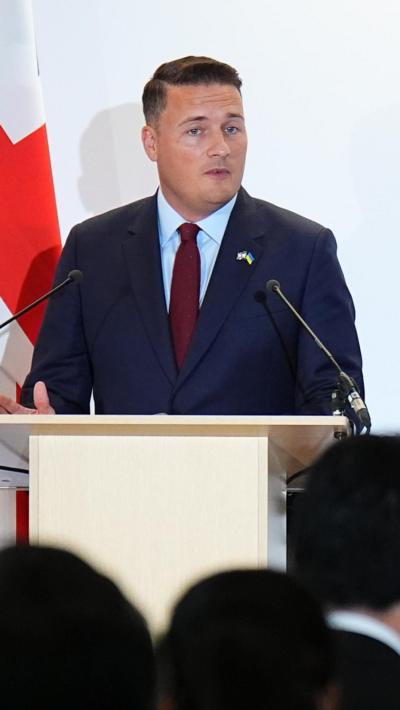 Wes Streeting speaks at a podium during a conference