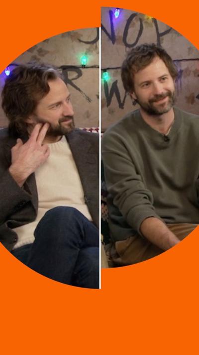 The Duffer Brothers sat together next to a Stranger Things 5 sign