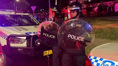 Two police officers stand outside a church with riot shields