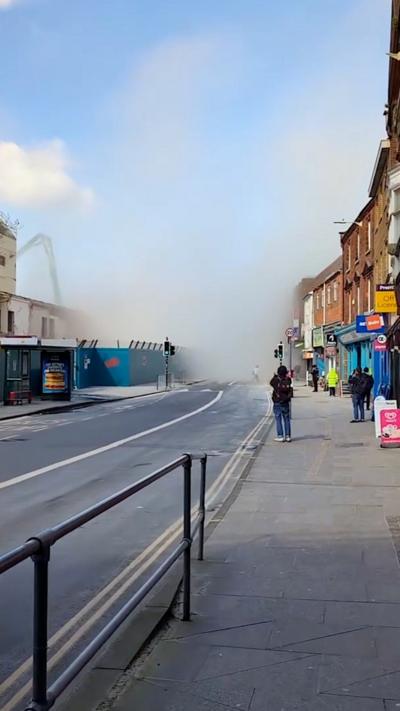 Dust fills the air and street after car park is demolished