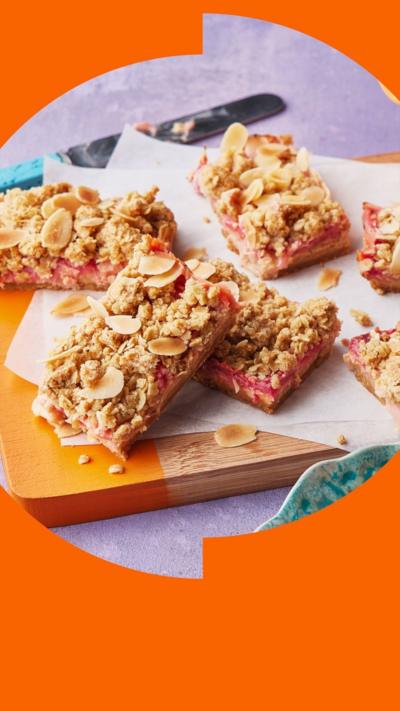 Four rhubarb bars sit on a wooden board
