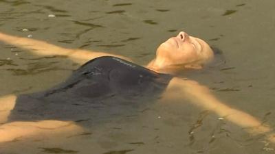 Woman floats on her back in a lake