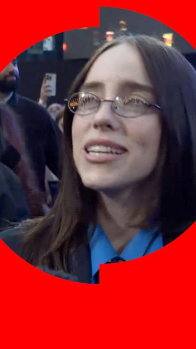 Billie Eilish, with long straight hair and glasses, smiling