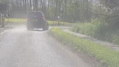 Car being drive wrong way around roundabout