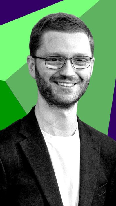 Scottish Greens co-leader Ross Greer smiles at the camera. He is wearing a t-shirt snd blazer.