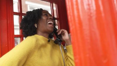 Shanequa in a red phone box