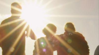 Silhouettes of people walking in the sun