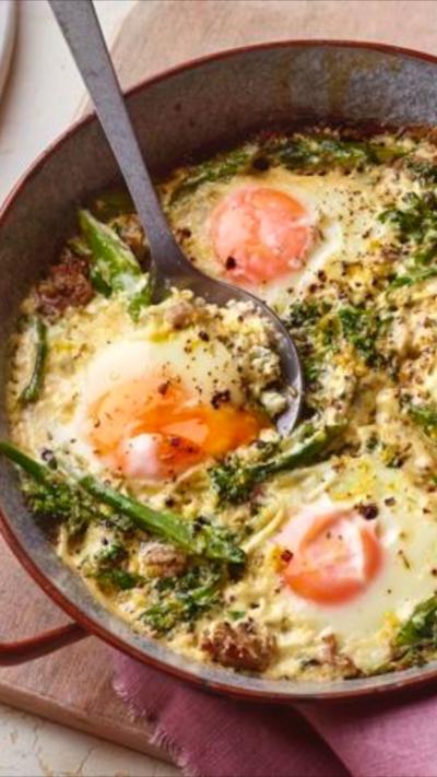 A dish with four baked eggs surrounded by broccoli in a sauce in it, sits on a pink napkin