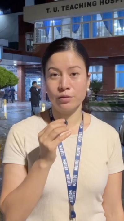 BBC reporter Shreejana Shrestha in a white shirt holding a mic.