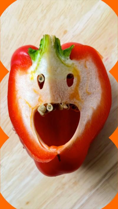 A red pepper cut in half, the inside looks like a human face