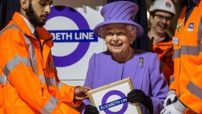 Queen Elizabeth holds a commemorative plaque