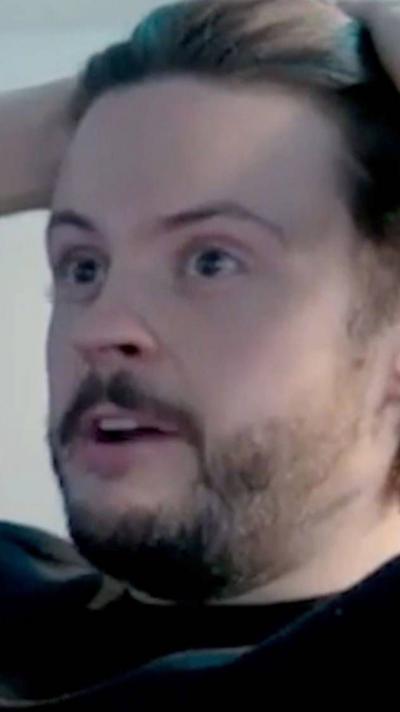 Man holds his head looking pleased