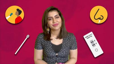 Dr Anita Raja surrounded by the items of a lateral flow test kit