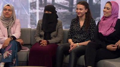 Three women wearing different types of Islamic dress and another without