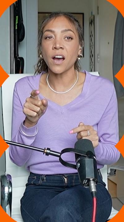 A woman sits in front of a microphone talking to someone across from her