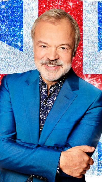 Graham Norton in a suit, behind him is a Union Flag image 